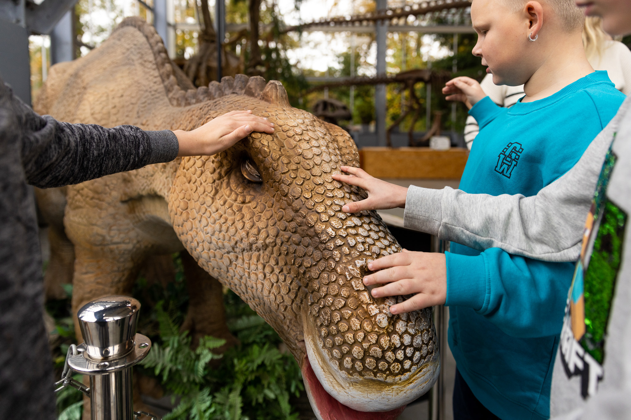 Het is spannend en leerzaam om dinosauriërs aan te raken in een museum, omdat je zo voelt hoe gigantisch en echt ze waren!