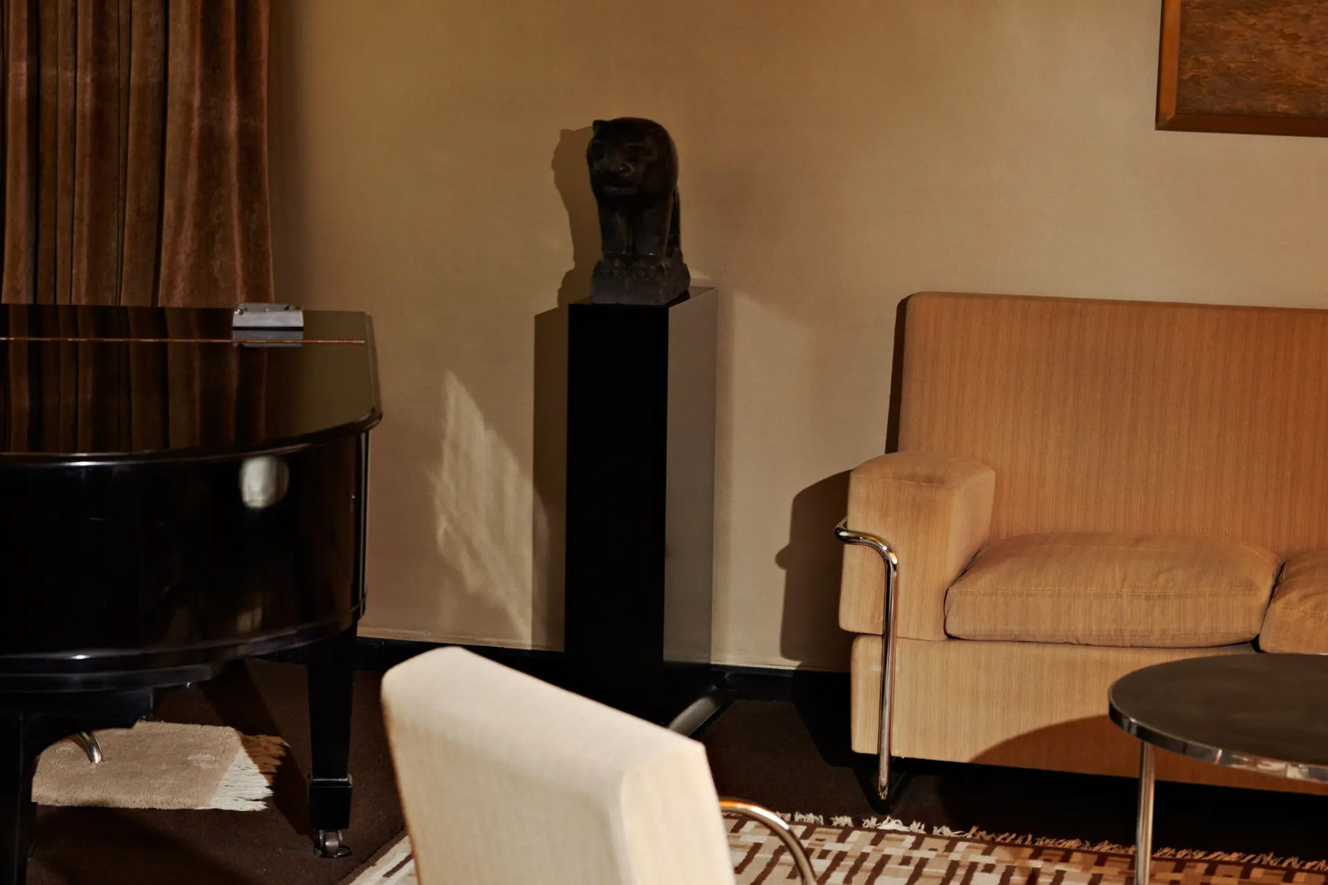Zitkamer met piano en het beeldje van John Raedecker op een sokkel. Foto Johannes Schwartz.